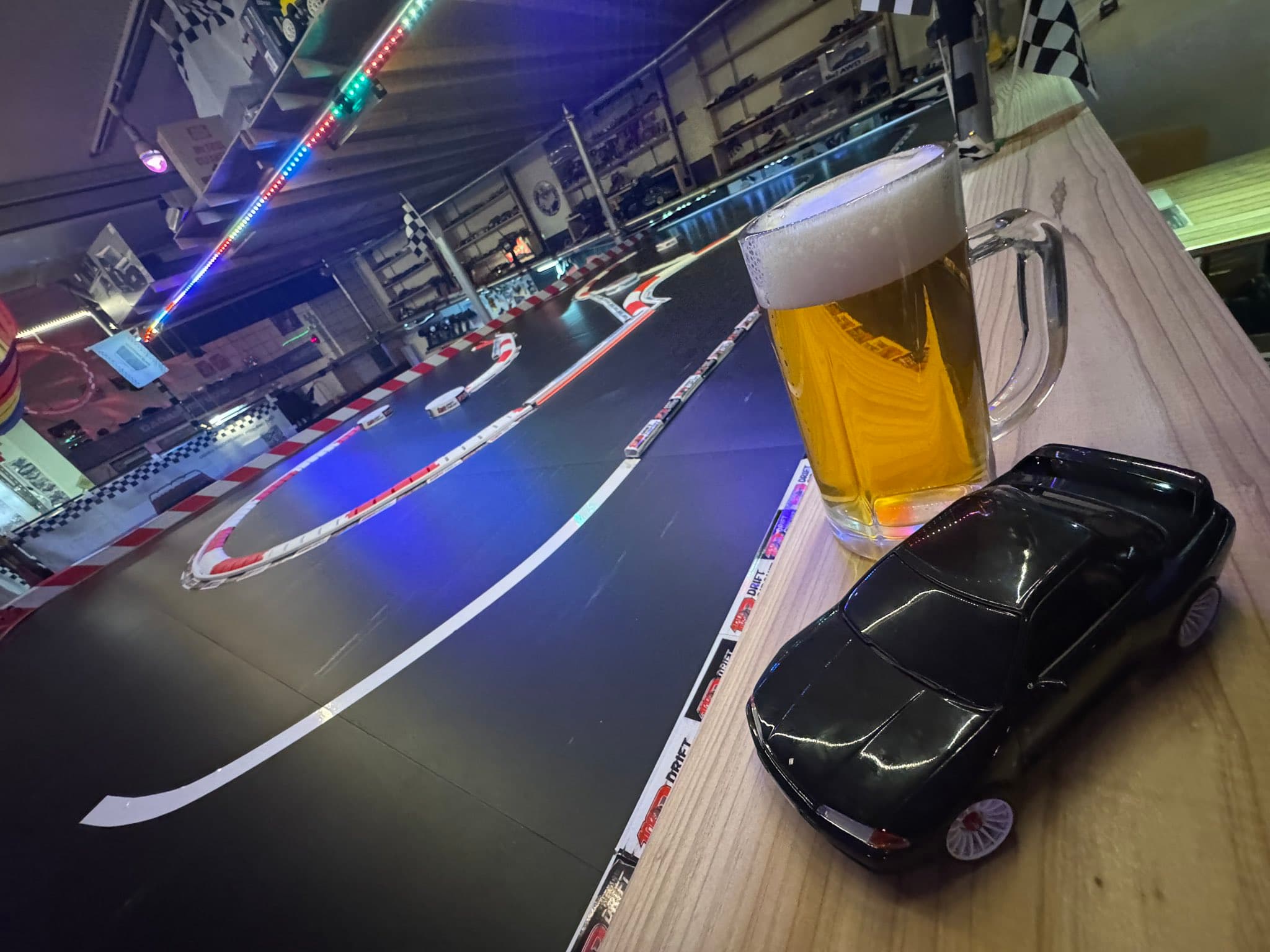 黒いドリフトRCマシンと飲み物が並ぶレーシングバー100Rの店内